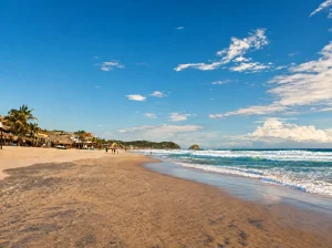 Playa de Zipolite con mar azul, arena dorada, olas blancas. Lugar ideal para el descanso